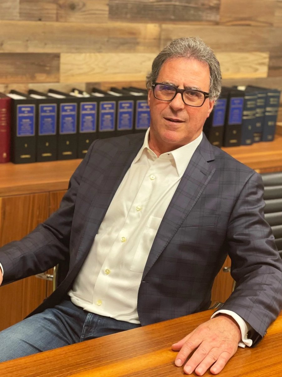 Timothy S.B. Danson at his desk, in front of shelves of law reports